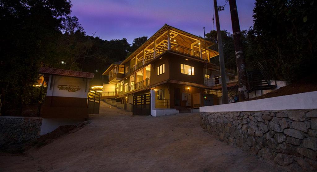 a large wooden building with lights on it at night at Terrace Resorts in Wayanad