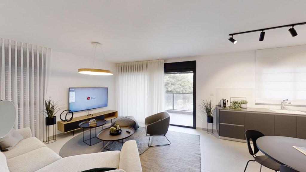uma sala de estar branca com um sofá e uma televisão em Luxury 3&4 Bedroom new apartments - close to the Beach & Bahai Gardens em Haifa