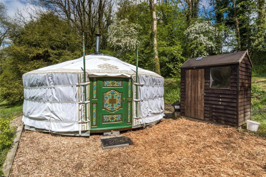 a yurt with a wooden house in a field at Pembrokeshire Yurts - Badger in Llanfyrnach