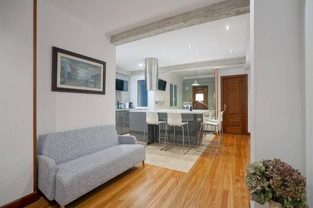 sala de estar con sofá y cocina en AMPLIO APARTAMENTO en GROS con PARKING PRIVADO, en San Sebastián