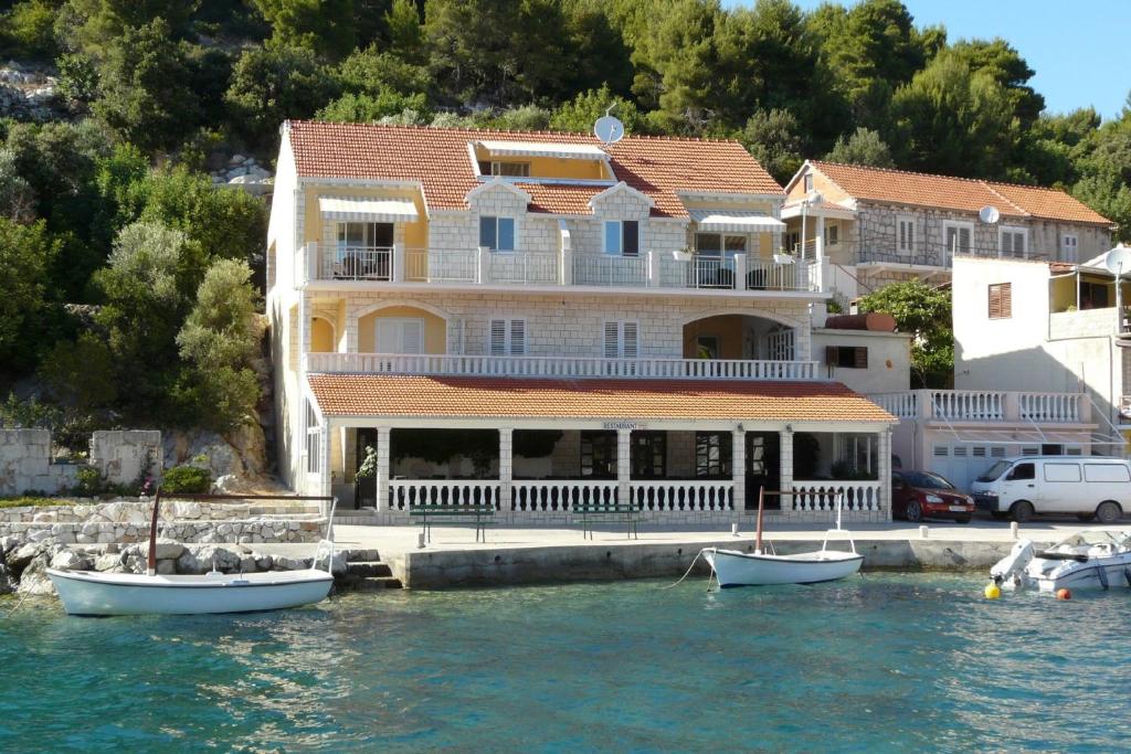 a large house on the water with boats in the water at Apartments Korčula in Prizba