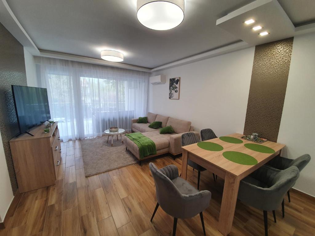 een woonkamer met een tafel en een bank bij Sunshine Resort Brown apartman in Zamárdi