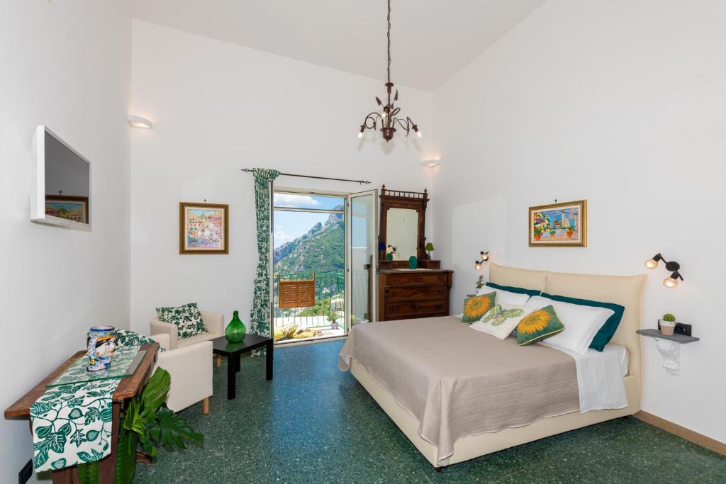 um quarto com uma cama, uma mesa e uma janela em YourHome - Casa Marina Positano em Positano