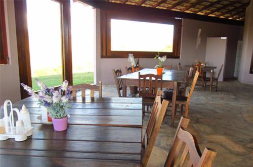 una sala da pranzo con tavolo e sedie in legno di Cataguás Brasil Pousada a Carrancas