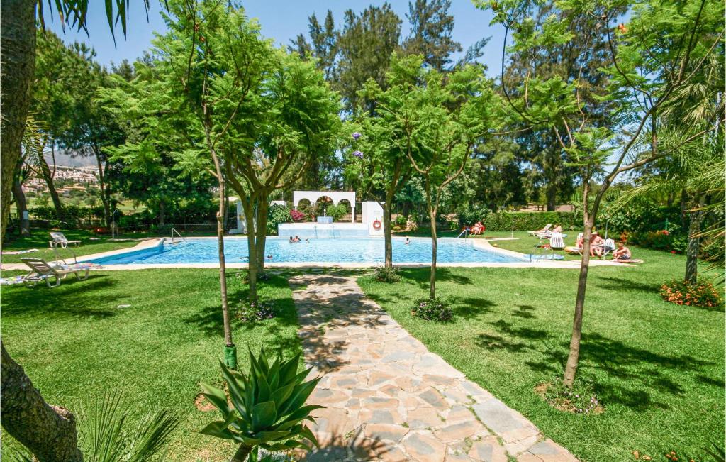 una piscina en un parque con árboles en Amazing Apartment In Mijas Costa With House A Mountain View, en Mijas Costa