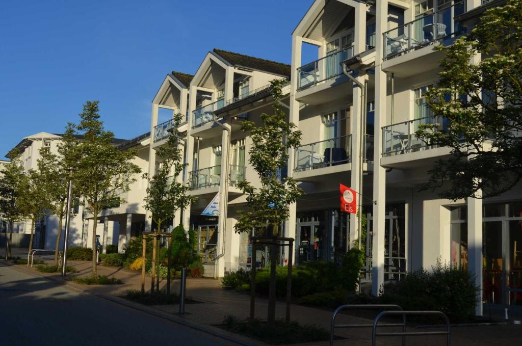 a white building with balconies on a street at Appartementanlage Villa Granitz 45 in Göhren