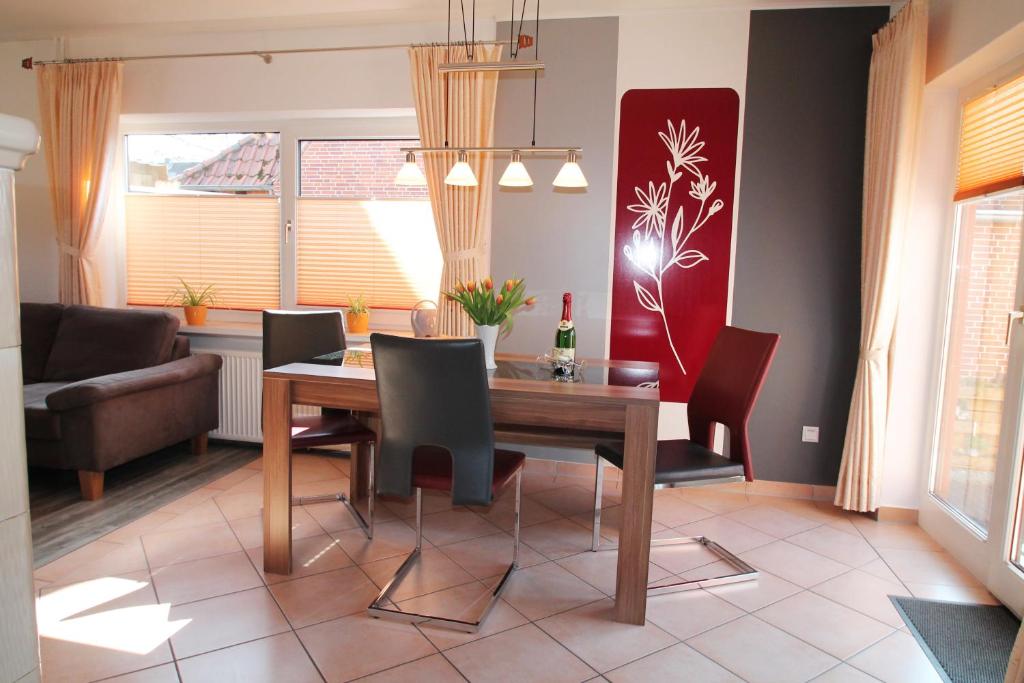 ein Esszimmer mit einem Holztisch und Stühlen in der Unterkunft Haus Clara in Husby
