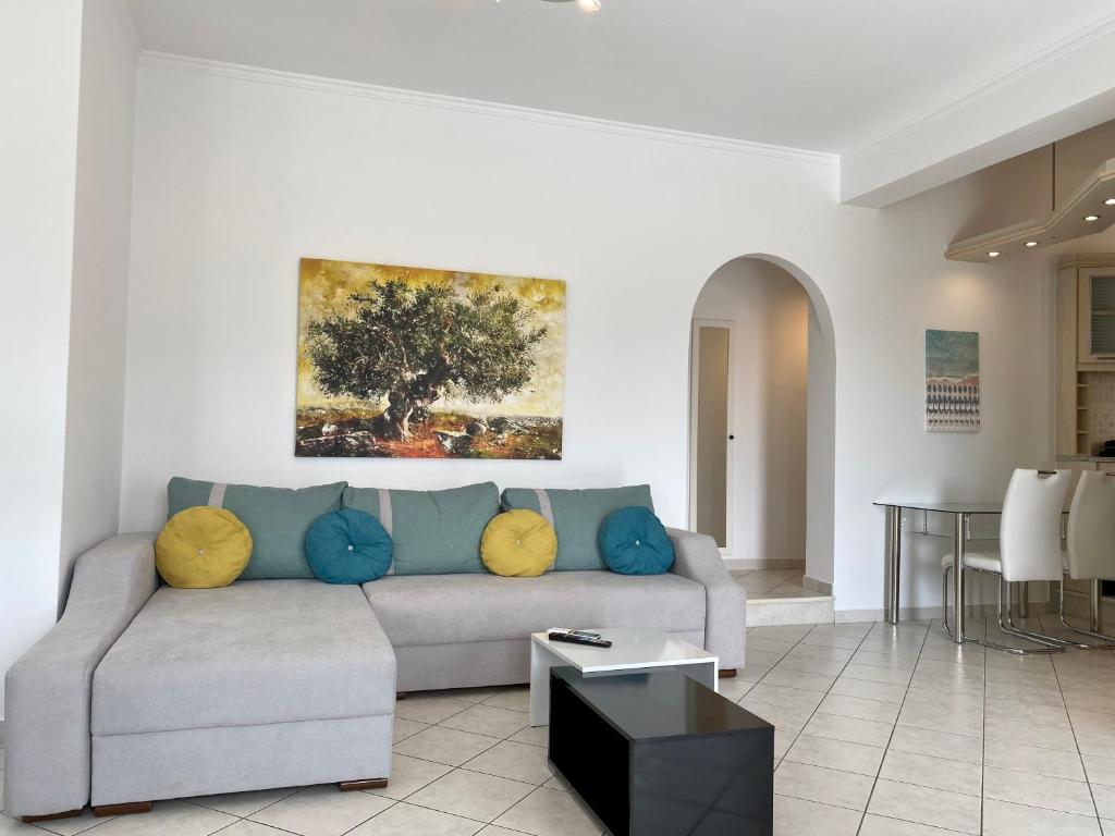 a living room with a couch and a painting on the wall at PORTA HOME modern and hospitable in Naxos Chora