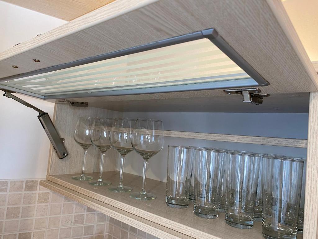 a row of wine glasses sitting on a shelf at PORTA HOME modern and hospitable in Naxos Chora