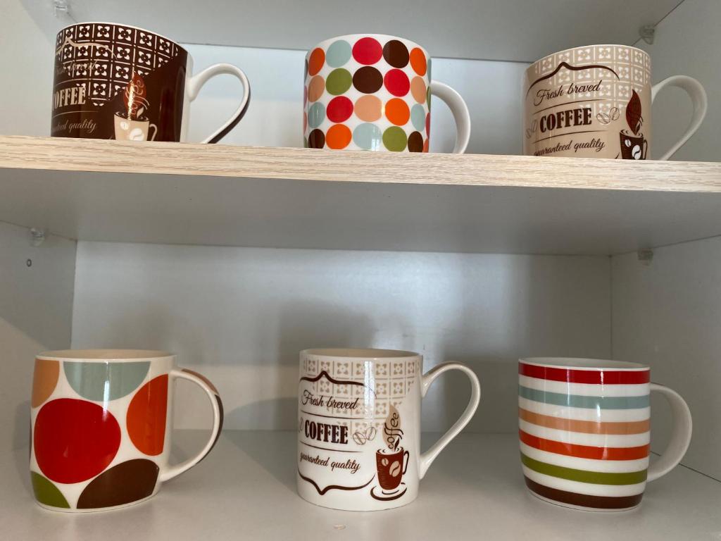 a shelf with three cups on it at PORTA HOME modern and hospitable in Naxos Chora