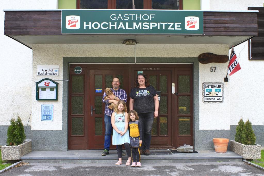 un groupe de personnes debout à l'extérieur d'un bâtiment dans l'établissement Gasthof Hochalmspitze, à Malta