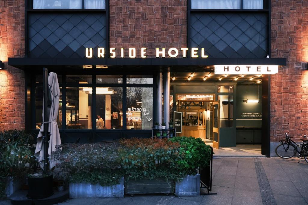 a hotel with an umbrella in front of a building at URSIDE Hotel Shanghai The Bund in Shanghai