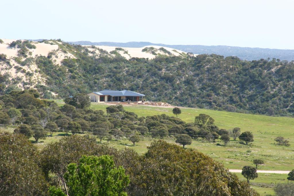 uma casa no topo de uma colina relvada em Almonta Park Lodge em Coffin Bay