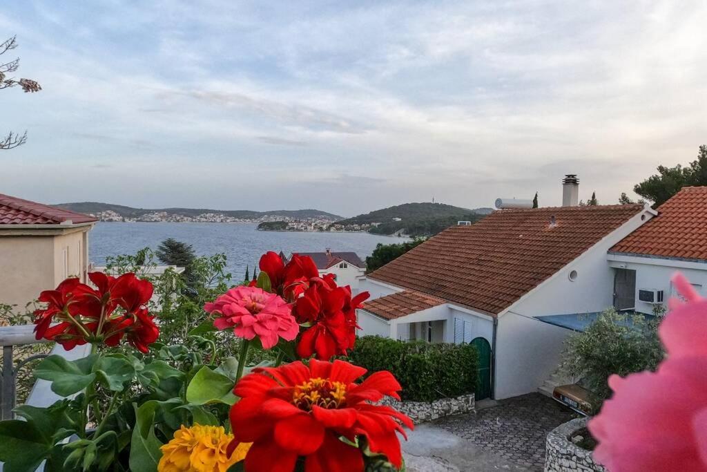 uma vista para a água de uma casa com flores em KN House with two apartments near sea em Rogoznica