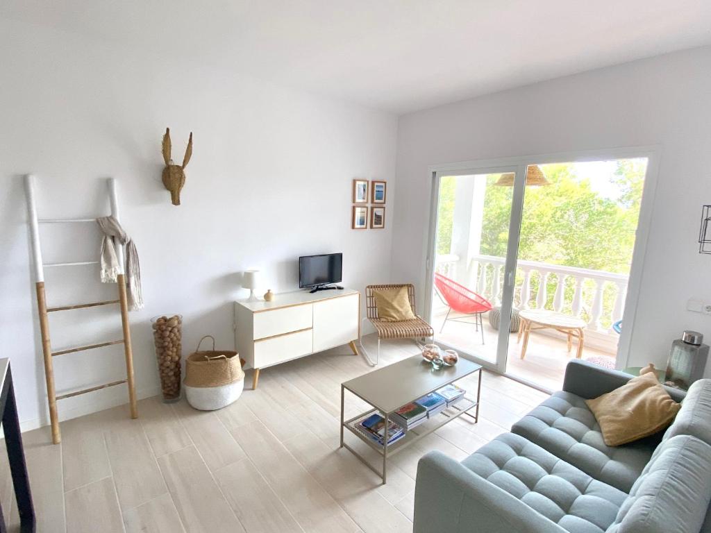 a living room with a couch and a table at Appartement NoBe Es Pujols proche plage, vue mer in Es Pujols