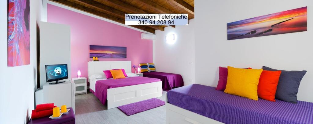 a room with purple and colorful pillows in a room at Arricàmpati Airport Rooms & Bringo Car Rental in Carini