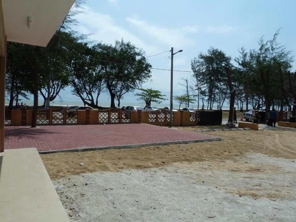 a basketball court in front of a fence with trees at Cempaka Beach Resort in Kuantan