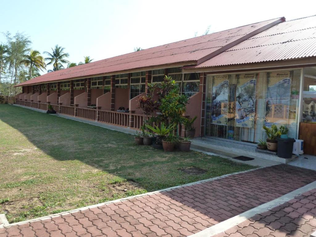 a building with windows and potted plants in front of it at Cempaka Beach Resort in Kuantan