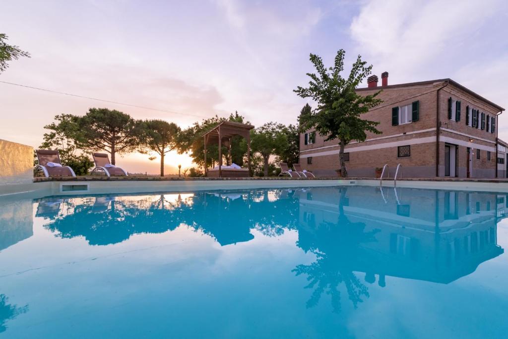 une grande piscine en face d'une maison dans l'établissement CASALE BONAVENTURA 8, Emma Villas, à Ostra