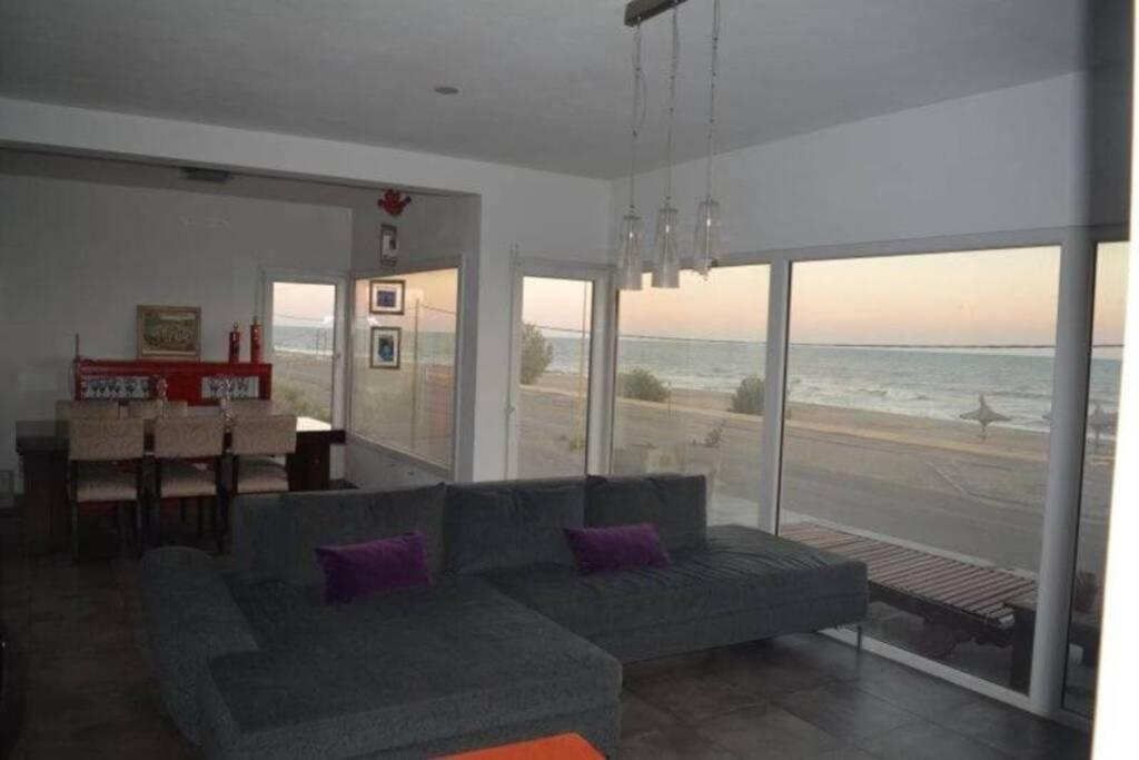 ein Wohnzimmer mit einem Sofa und Strandblick in der Unterkunft CASA AL LADO DEL MAR in Balneario El Cóndor