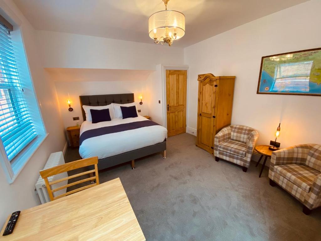 um quarto com uma cama, uma cadeira e uma mesa em Self Contained Guest suite 2 - Weymouth em Weymouth