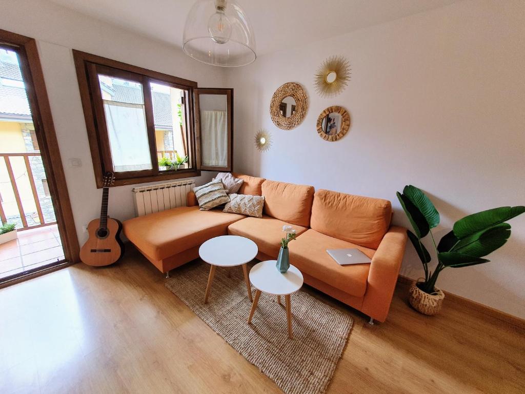 sala de estar con sofá y guitarra en Apartamento de montaña y ESQUÍ en el Pirineo Aragonés, Villanúa - WIFI, en Villanúa