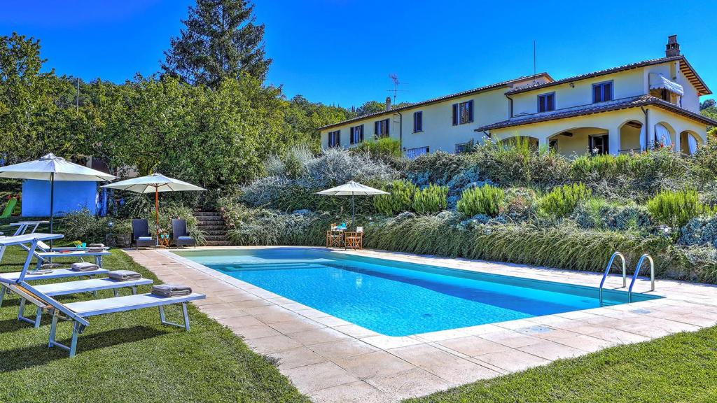 a swimming pool in the yard of a house at Casale Le Conce 62 Emma Villas in Castel del Piano