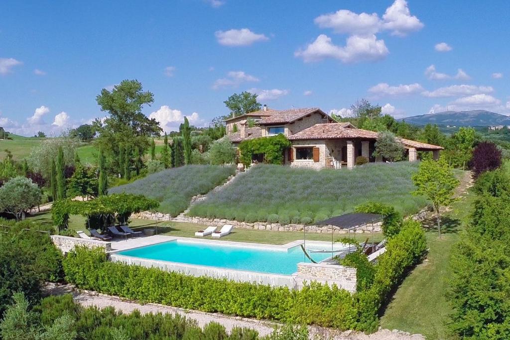 an estate with a swimming pool in front of a house at CASALE DELLE LAVANDE 10, Emma Villas in Todi
