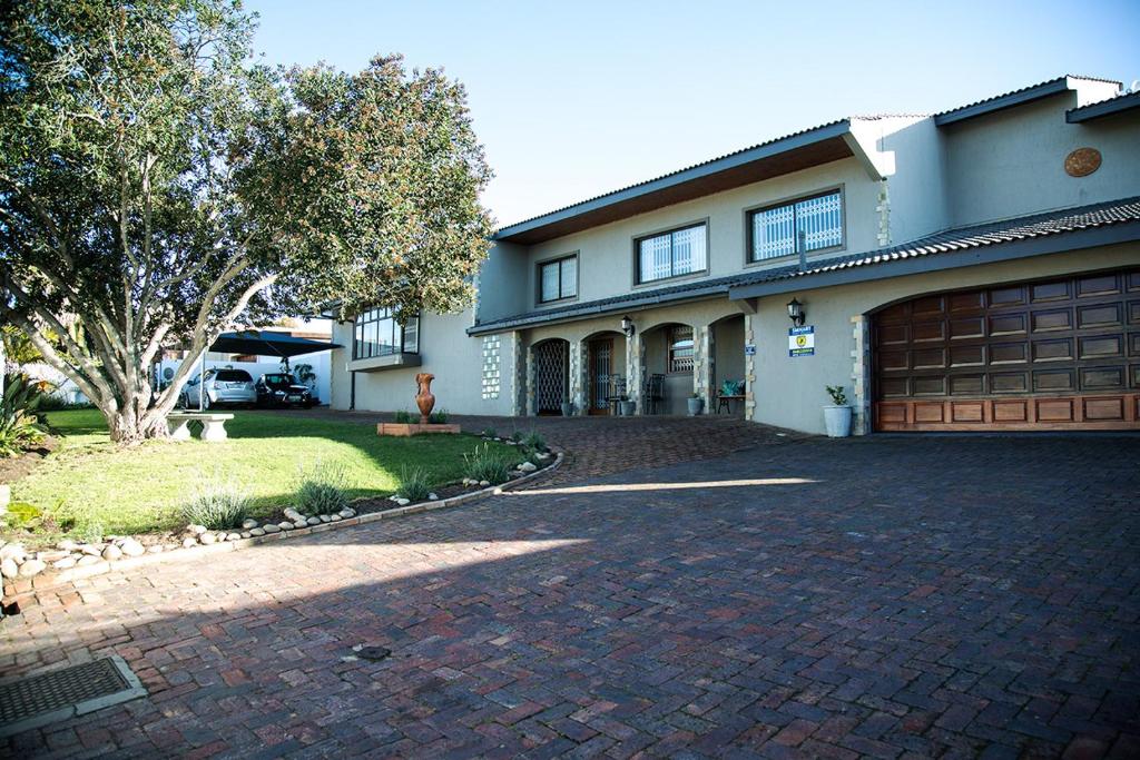 une maison avec une allée en briques et un garage dans l'établissement Place des Amoureux - No loadshedding, à Plettenberg Bay