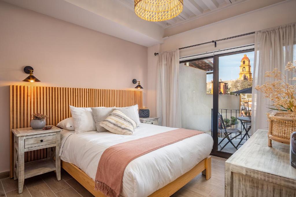 una camera con un grande letto e un balcone di Casa Pandurata Luxury Apartments in Centro, San Miguel de Allende a San Miguel de Allende