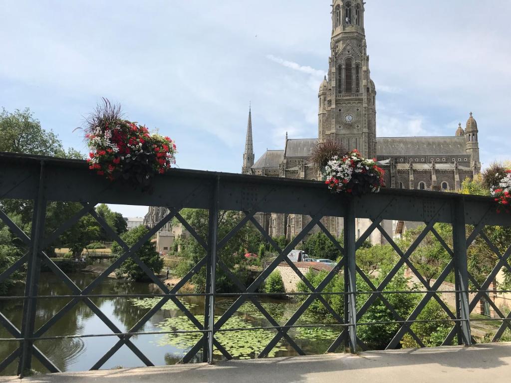 a bridge in front of a cathedral with flowers on it at Les Papoulis in Saint-Laurent-sur-Sèvre