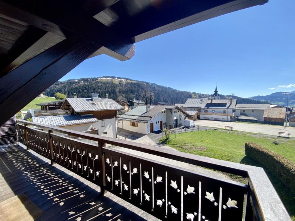 a balcony with a view of a town with buildings at La Troïka in Notre-Dame-de-Bellecombe