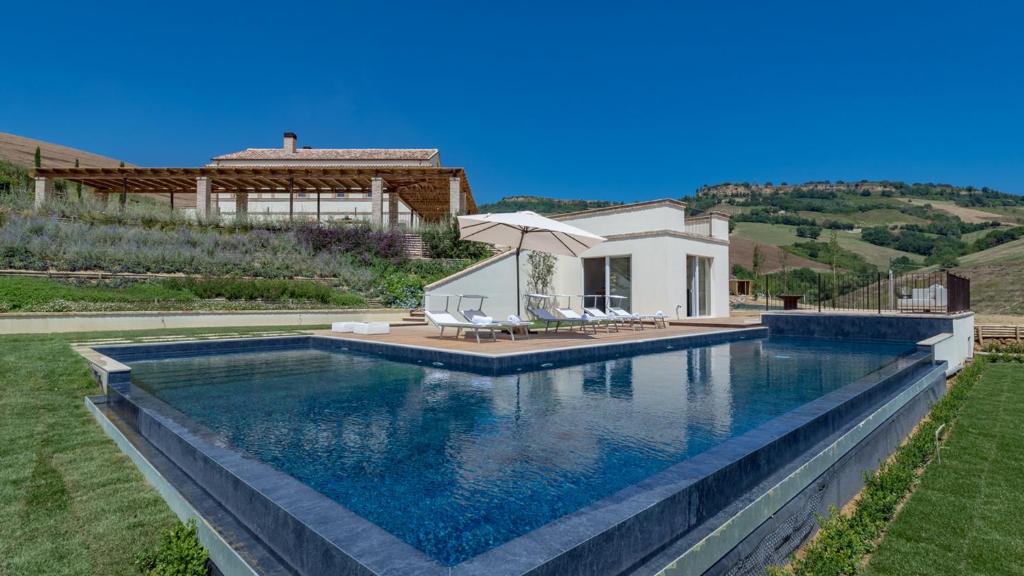 uma piscina em frente a uma casa em Dimora Montefiore 11, Emma Villas em Montefiore dellʼAso