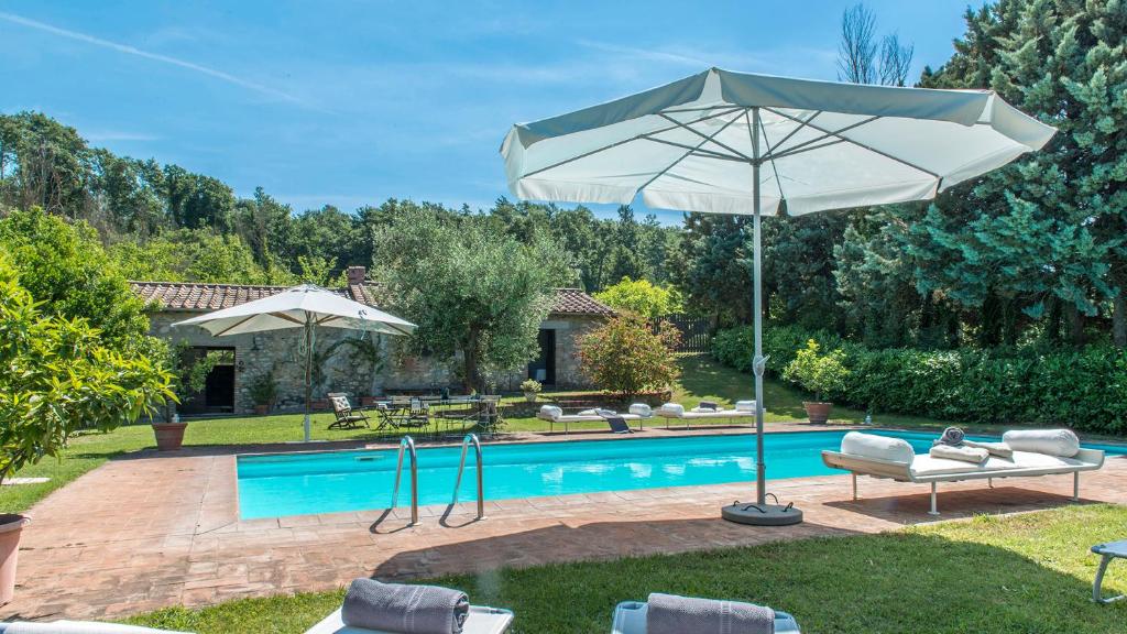a pool with an umbrella and chairs and a table at I PIANTONI 10, Emma Villas in Penna in Teverina