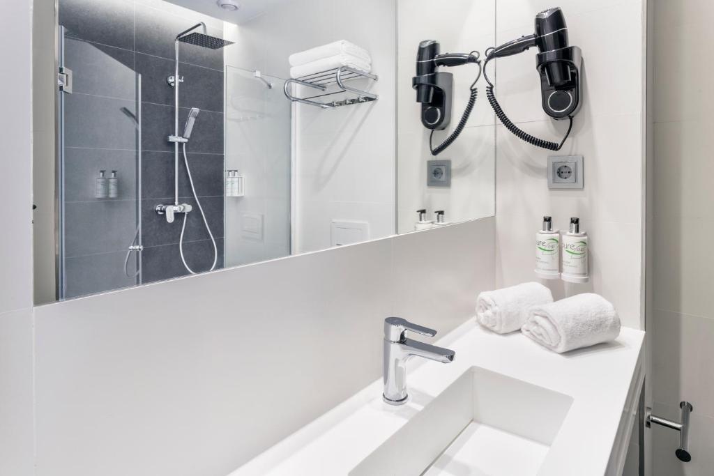 Un baño blanco con lavabo y ducha. en B&B HOTEL Murcia, en Murcia