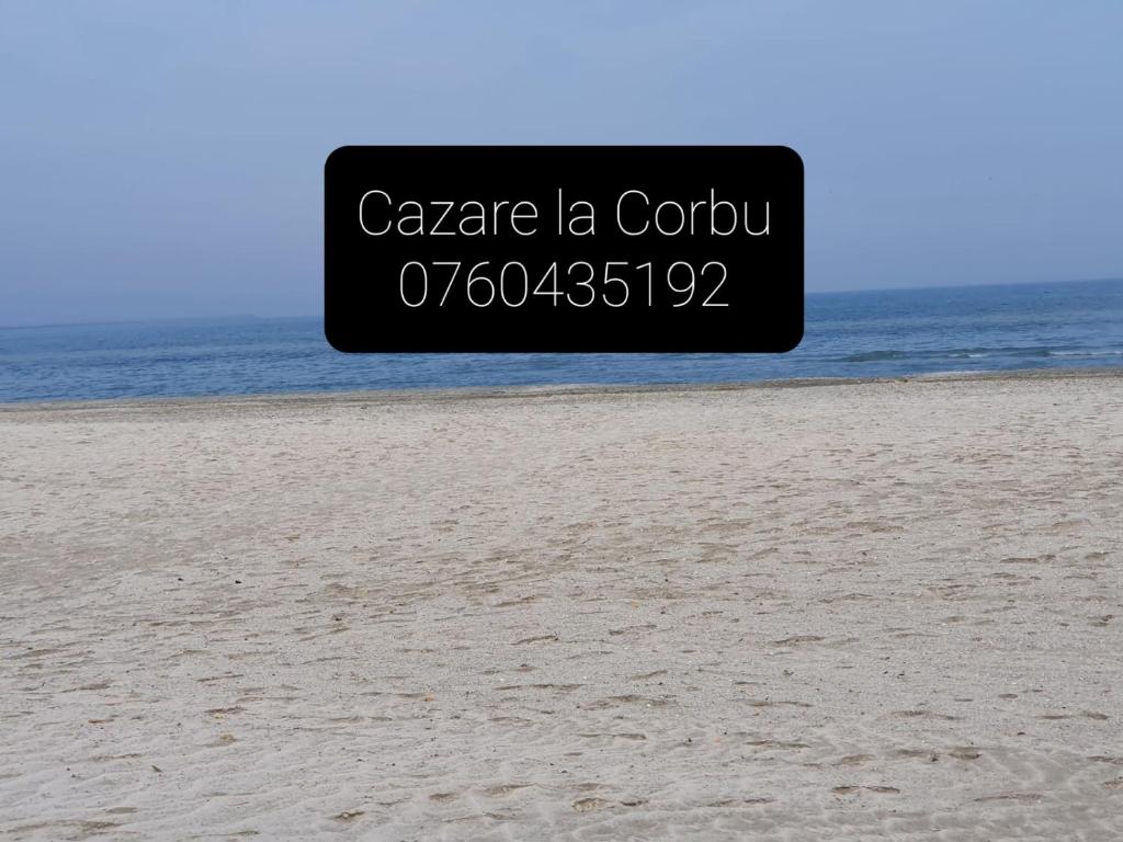 un panneau sur la plage avec l'océan en arrière-plan dans l'établissement Dalila, à Corbu