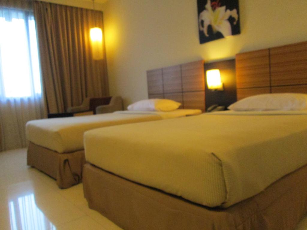 Postel nebo postele na pokoji v ubytování Hotel Kini Pontianak
