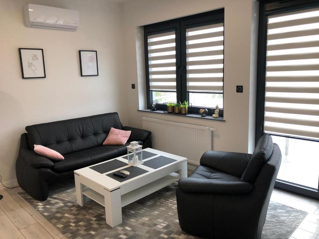 a living room with two black couches and a coffee table at Apartament Plaza Premium in Słupca