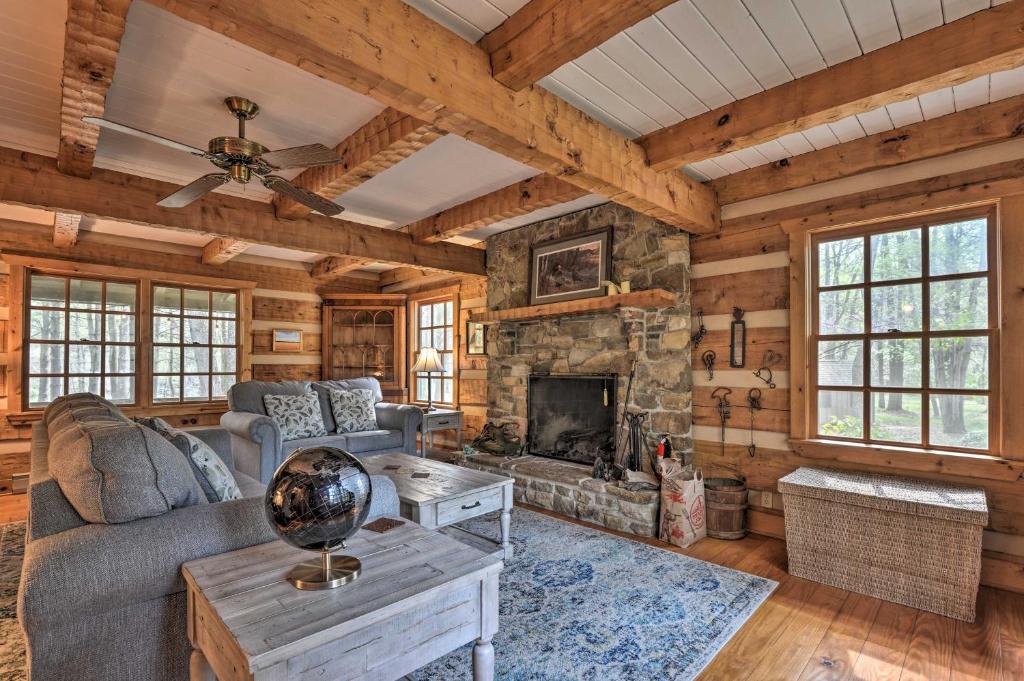 a living room with a couch and a fireplace at Riversong Cabin with Fire Pit on North River in Slanesville