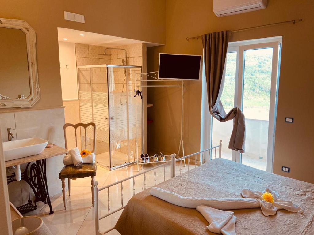 a bedroom with a bed and a sink and a mirror at Il Panorama Housing Cilento in Santa Maria di Castellabate