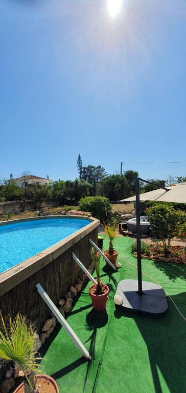a swimming pool with plants on a green lawn at Hakuna matata in Benagil