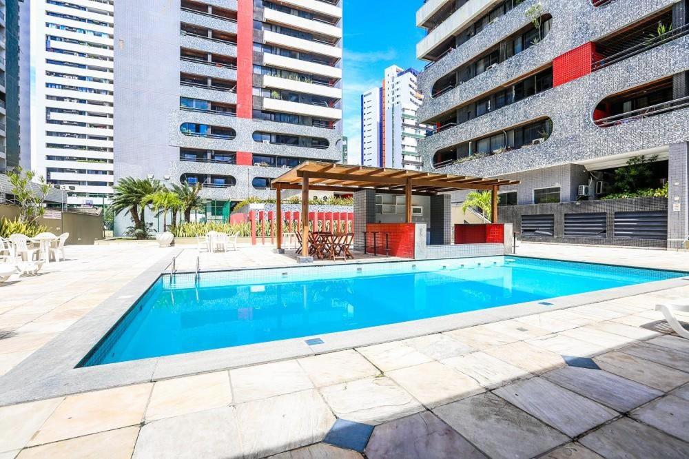 a swimming pool in the middle of a building at Apartamento tipo Flat em Boa viagem com serviços inclusos in Recife