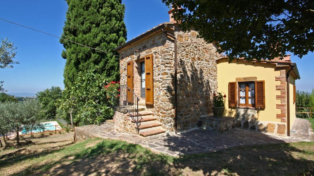 uma pequena casa de pedra num jardim com uma árvore em Monterzi 4, Emma Villas em San Giovanni dʼAsso