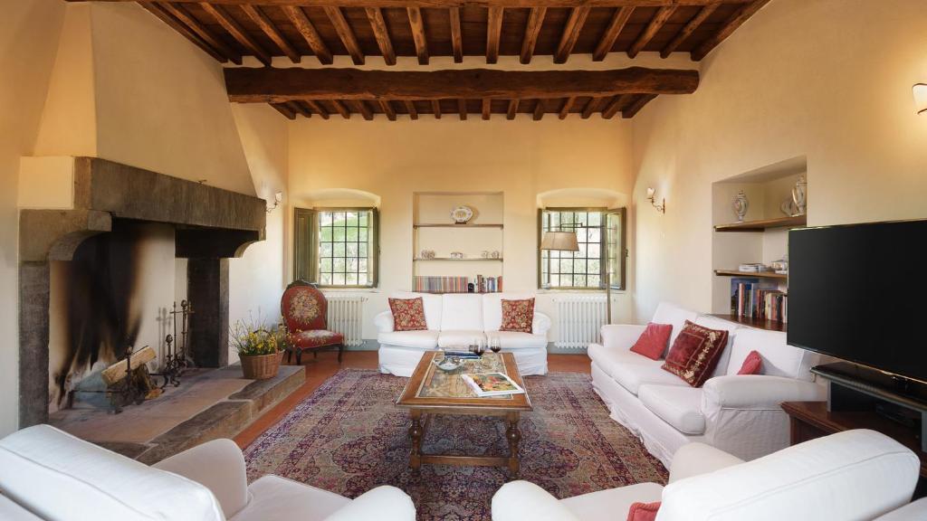 - un salon avec des canapés blancs et une cheminée dans l'établissement Marangole 12, Emma Villas, à Radda in Chianti
