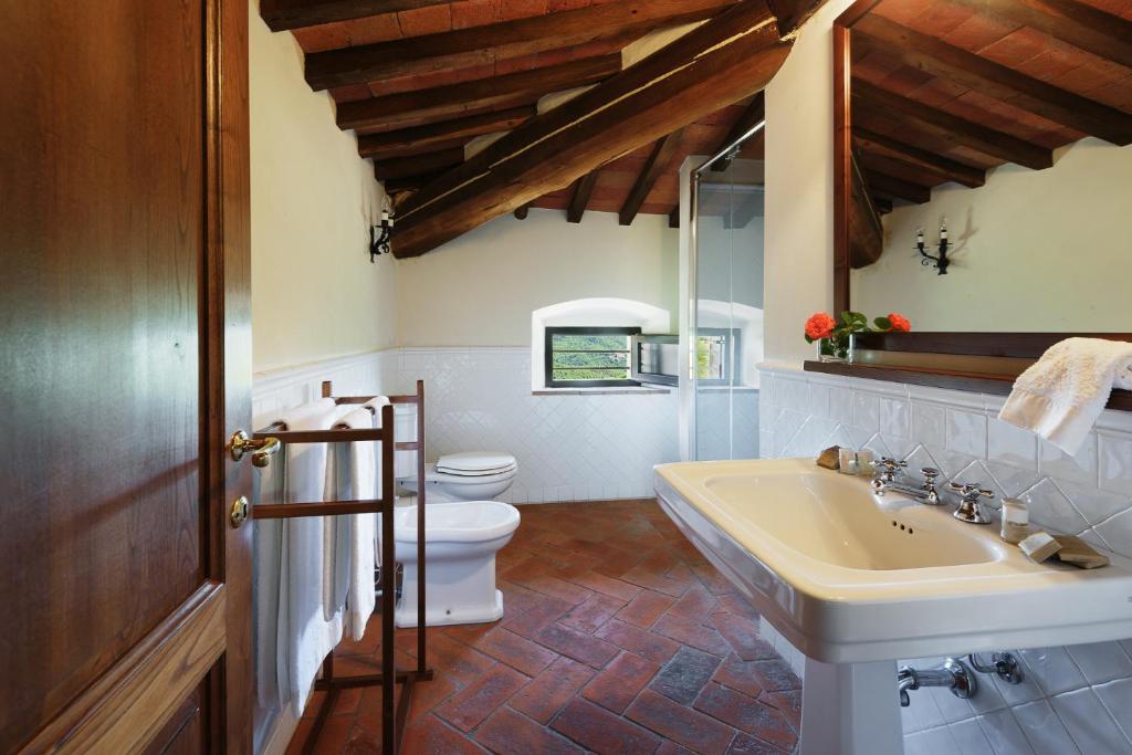une salle de bain avec un lavabo et des toilettes dans l'établissement Marangole 12, Emma Villas, à Radda in Chianti