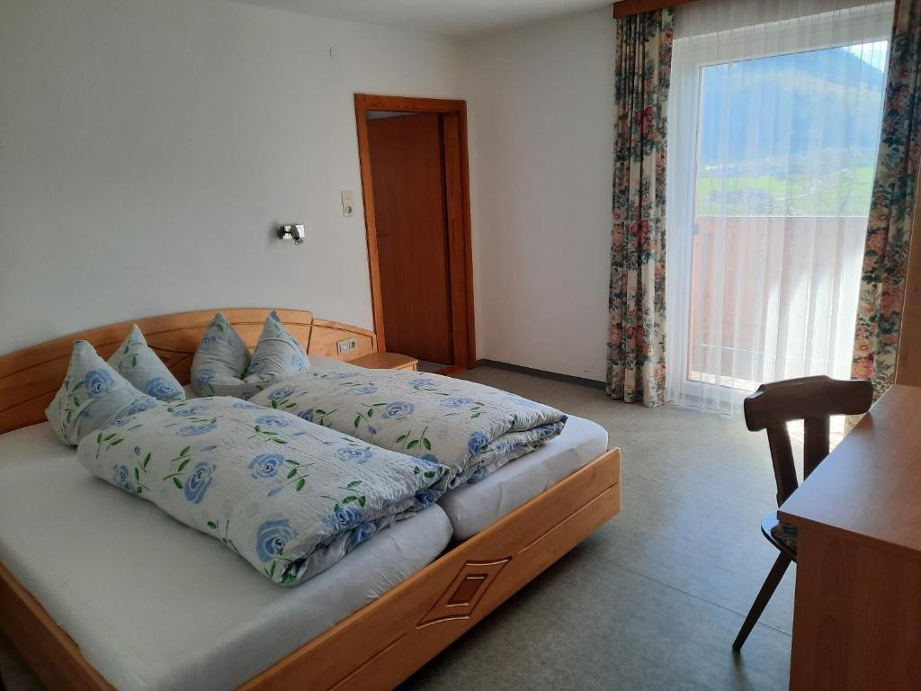 1 dormitorio con cama con almohadas y ventana en Grünwald Chalet, en Maishofen