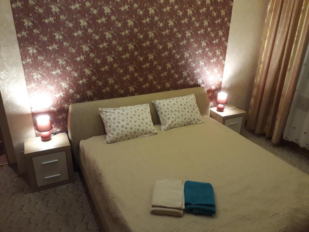 a bedroom with a large bed with two lamps on it at Saulriets in Liepāja