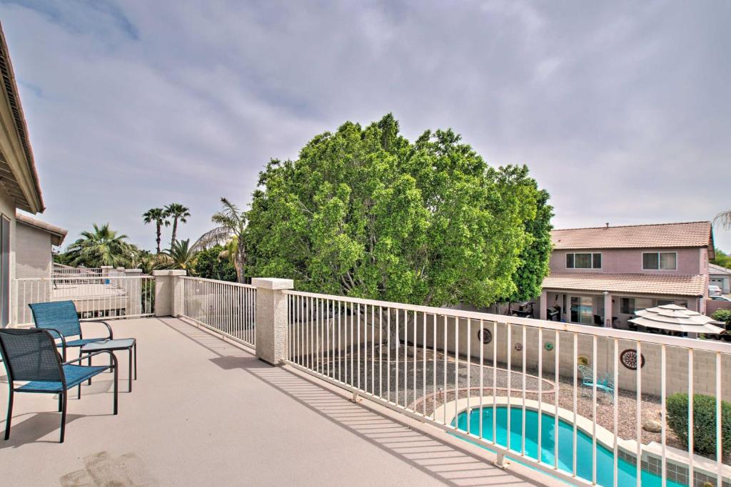 a balcony with two chairs and a swimming pool at Spacious Goodyear Retreat - Walk to Wigwam! in Goodyear