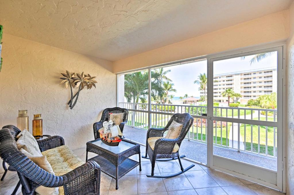 een woonkamer met 2 stoelen en een balkon bij Oceanfront Bonita Beach Condo with Pool Access! in Bonita Springs