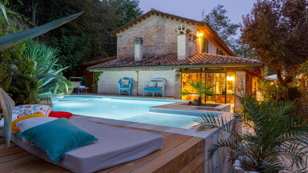 a swimming pool in front of a house at Villa Agave 8, Emma Villas in Monteciccardo
